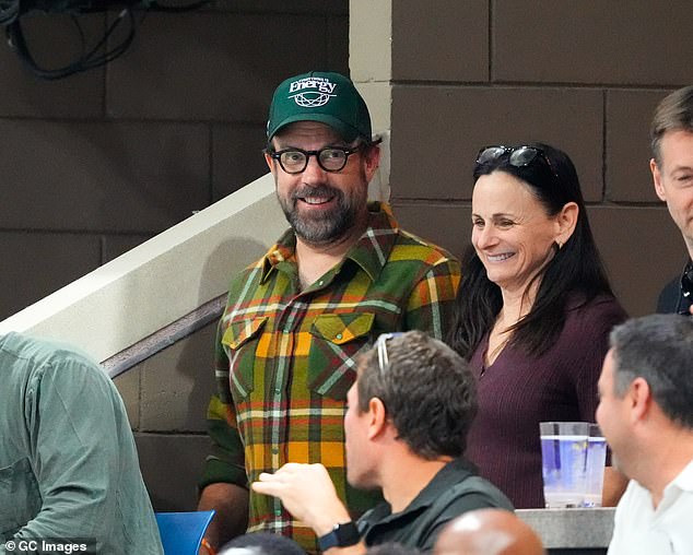 He seemed in good spirits as he chatted with other guests in the stands.