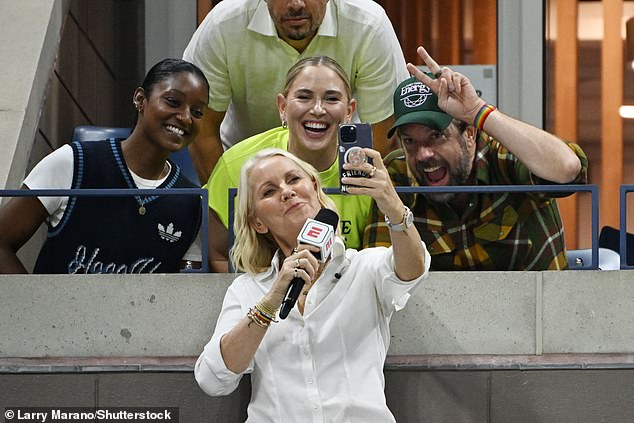 The Australian tennis coach cut a chic figure in a textured white shirt and accessorised with a layer of gold necklaces as she took a selfie with Jason.