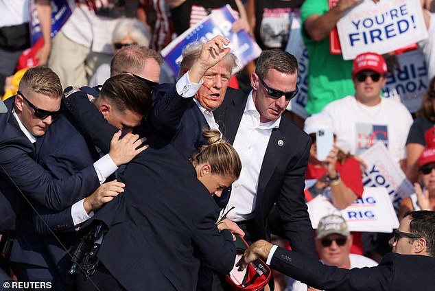 With blood running down his face, Trump raised his fist toward his supporters.