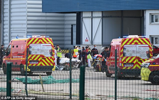 Firefighters handle the bodies of migrants who died trying to cross the Channel to England in Boulogne-sur-Mer, northern France, on September 3.