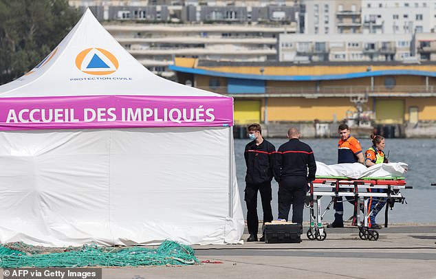 Firefighters and Civil Protection agents next to bags containing the bodies of migrants