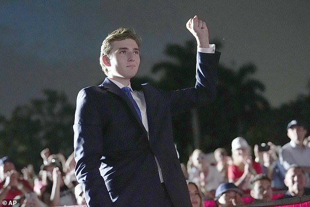 Trump raises his fist as his father speaks at a campaign rally at Trump National Doral Miami, Tuesday, July 9, 2024, in Doral, Florida.