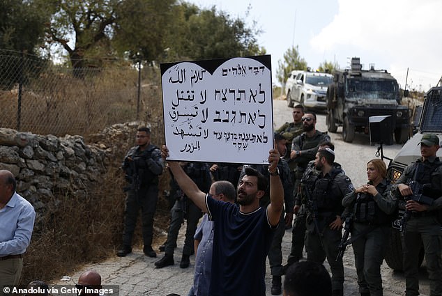 A group of activists holding banners stage a protest in the Makhror area against the forced displacement of Palestinians and the demolition of their homes by Israeli forces on September 3, 2024.