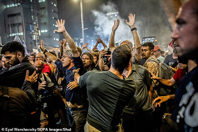 Israeli protesters are repelled by plainclothes police officers during a demonstration in front of the Ministry of Defense last night