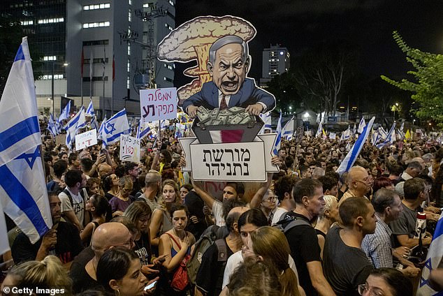 An Israeli protester carries a sign in Hebrew reading 'Netanyahu's legacy' at a mass rally last night condemning Prime Minister Benjamin Netanyahu and his handling of the hostages.