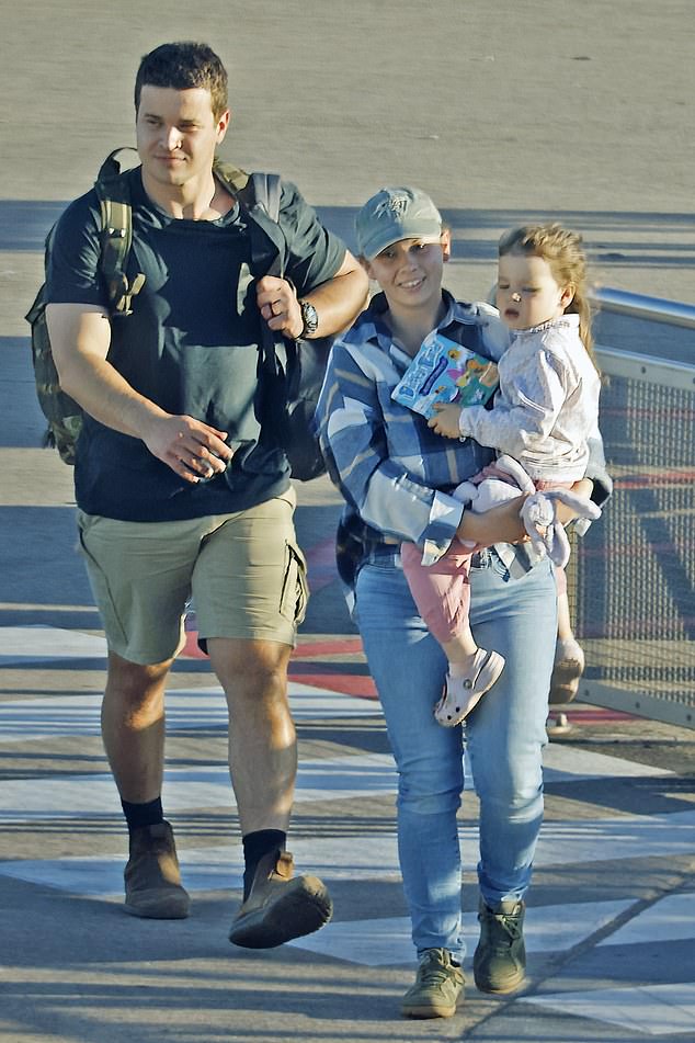 Bindi Irwin, 25, was a doting mother as she cradled her two-year-old daughter, Grace Warrior, while walking through Brisbane Airport on Monday.