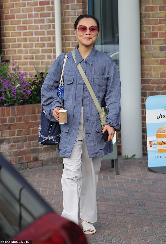 Nancy Xu looked chic in an oversized blue utility jacket and cream pants as she clutched a cup of coffee and her phone as she made her way toward the contestants.