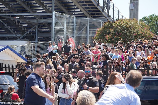 A crowd of students wait to be picked up by their parents after the shooting.