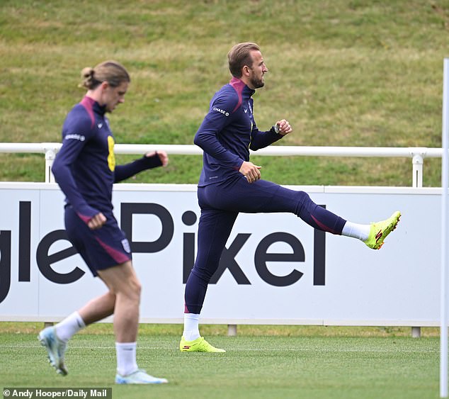 Two England players playing abroad, Atletico Madrid midfielder Conor Gallagher (left) and Bayern Munich striker Harry Kane (right), pictured doing some light stretching.