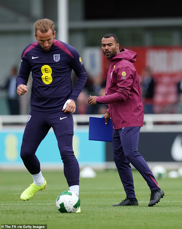 Three Lions captain Kane pictured controlling a ball as coach Cole watches from nearby.