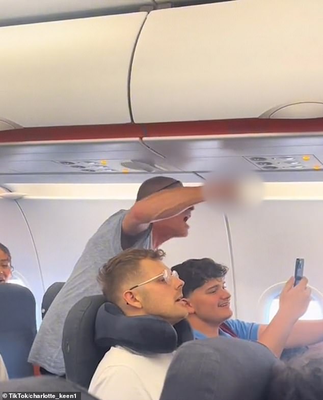 Passengers were left furious after the drunk passenger caused their flight to be diverted to Munich after trying to open the exit door during the flight (pictured: an angry passenger who told the unruly traveller that 