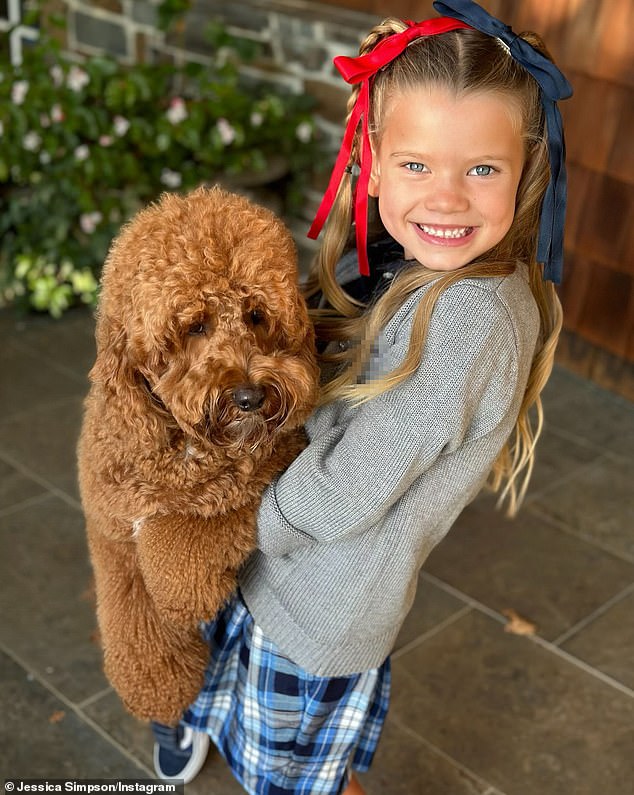 And little Birdie, hugging doodle Penny Lane, flashed a smile in her two-tone bows, a grey cardigan over a black polo, a blue plaid skirt and black Vans sneakers.