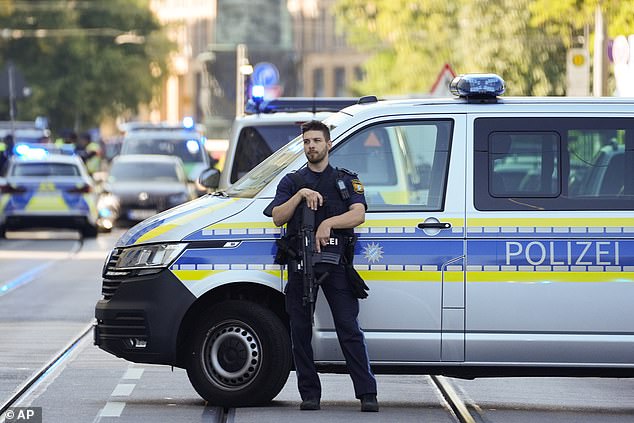 A police officer blocks a street after police shot a suspicious person near the Israeli consulate and a museum about the city's Nazi-era history in Munich, Germany, Thursday, Sept. 5, 2024.