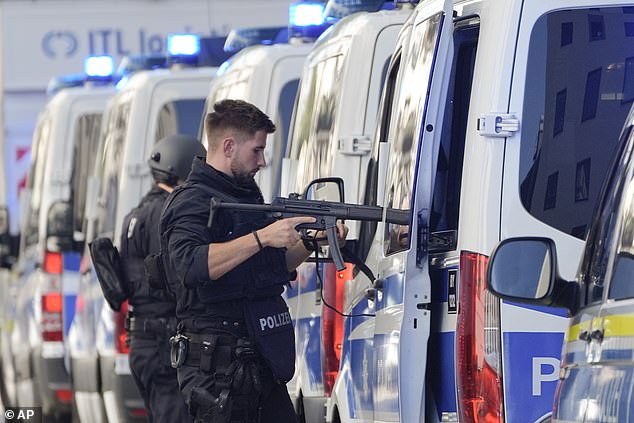 Police officers stand next to their cars after police shot a suspicious person near the Israeli Consulate and a museum about the city's Nazi-era history in Munich, Germany, Thursday, Sept. 5, 2024.