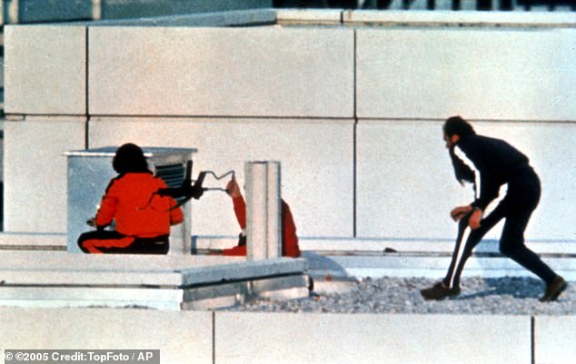 Two West German policemen dressed in tracksuits and armed with submachine guns take position on the roof of the Munich Olympic Village building where armed Arab men are holding members of the Israeli Olympic team hostage on 6 September 1972.