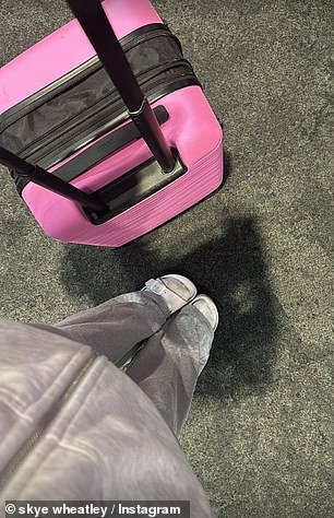 In one photo, she looked ready to travel, comfortable in grey sweatpants as she pushed her bright pink suitcase through the departures area.