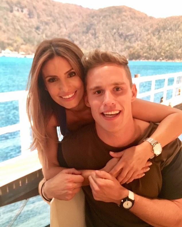 In the first flashback photo, a younger Scott can be seen posing alongside Ada Nicodemou, looking dapper and sporting a boyish smile. He looks every bit the Summer Bay hunk in a casual brown t-shirt as Ada wraps her arms around him in an outdoor setting. Both are pictured.