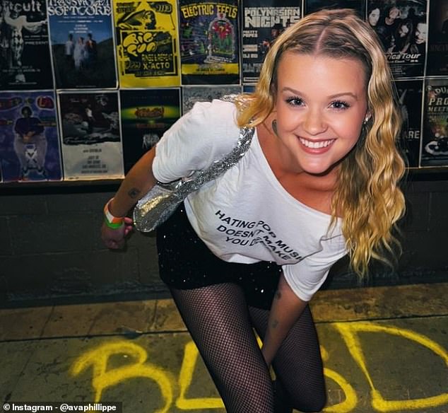 Ava smiling in June with her natural blonde hair. Her t-shirt reads: 