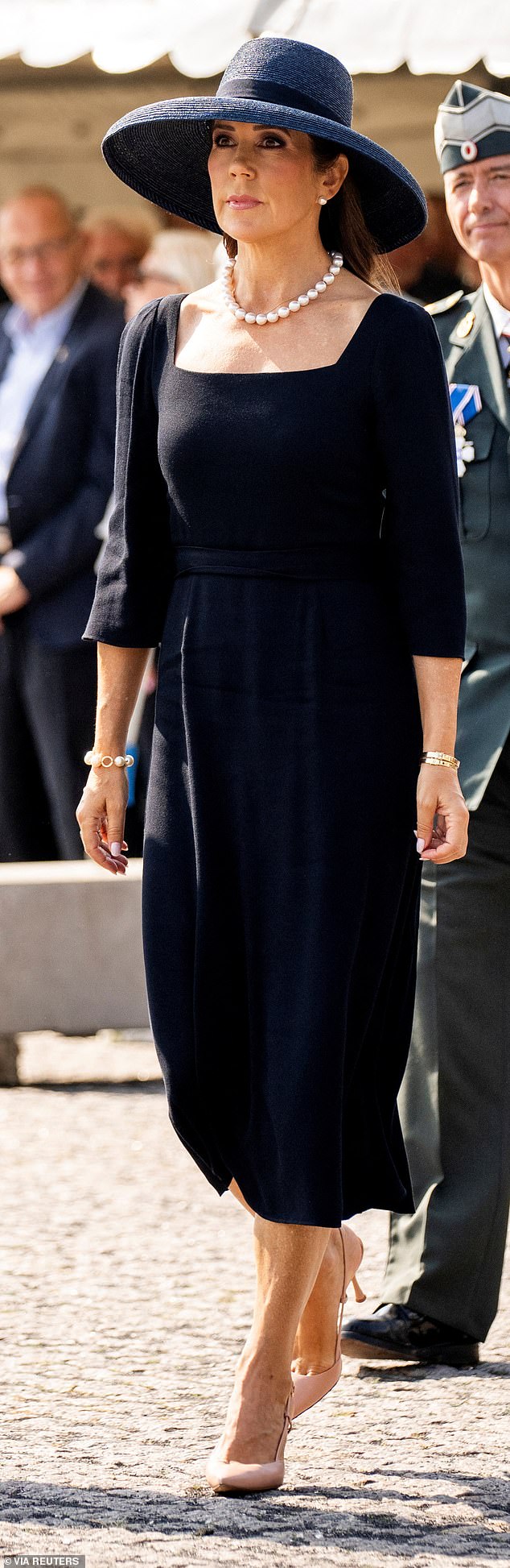 Mary wore a simple yet elegant black dress with a square neckline and quarter-length puffed sleeves and pink strappy heels.