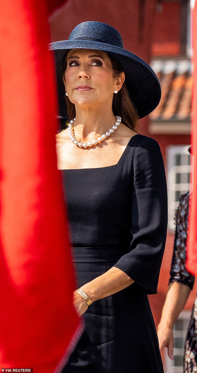 The Queen wore her shiny brunette locks down with a sleek blow-dry and opted for smoky eyeshadow and pink lipstick.