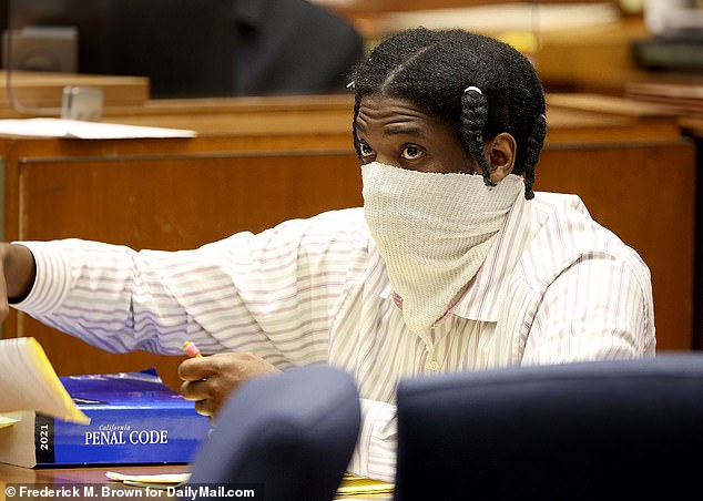 Photos obtained by dailymail.com show the accused murderer wearing a striped button-down shirt and a cloth face mask.