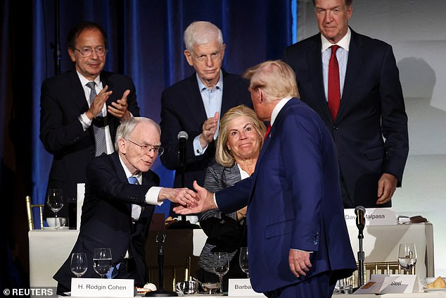 Republican presidential candidate and former US President Donald Trump shakes hands with Sullivan & Cromwell Chairman H. Rodgin Cohen at the Economic Club of New York