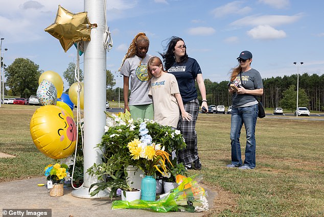 Grieving students have been steadily arriving outside the school on Thursday to mourn the tragedy.