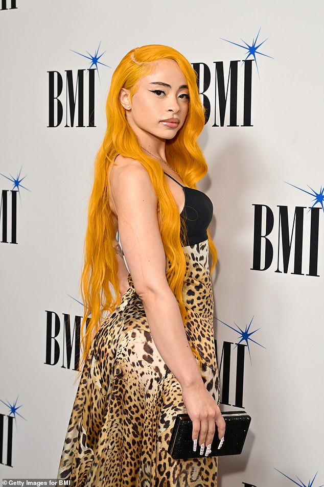 The 24-year-old rapper put on a sultry display in a low-cut slip dress with a sexy keyhole neckline and a loose leopard-print skirt that hugged her curves and trailed behind her.