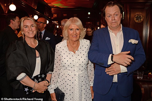 A radiant Queen Camilla can't help but smile as she poses with her children Tom and Laura.