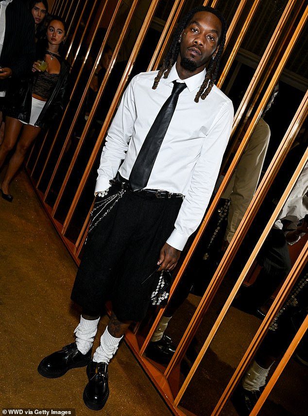 American rapper Offset, 32, wore a white long-sleeved shirt with a black tie and long black shorts with silver chains on one pocket.