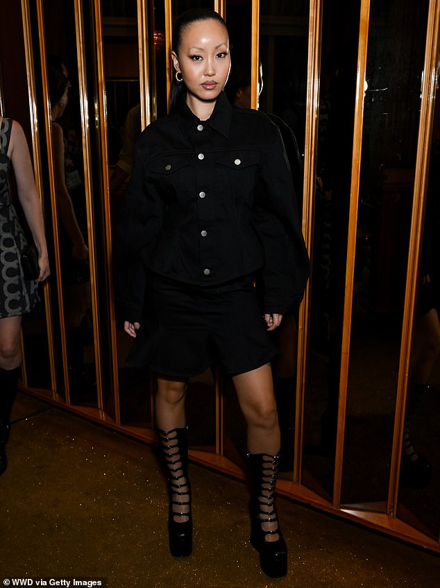 Fiffany Luu looked chic in a loose black denim dress and black multi-strap boots that reached just below the knee.