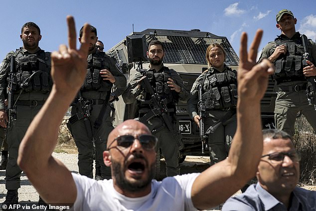 The Turkish-American citizen was a volunteer for the Faz3a campaign, which works with Palestinian farmers demonstrating against Israeli settlements. Pictured: Protesters sit in front of Israeli border guards during an earlier protest vigil