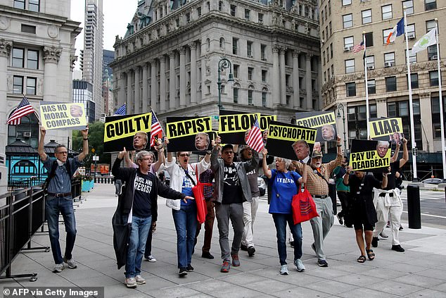 Protesters holding signs that read 