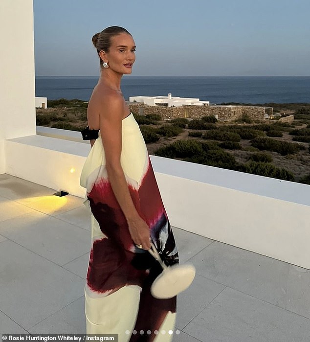 The striking white dress hugged her supermodel figure perfectly, showcasing a maxi red floral print.