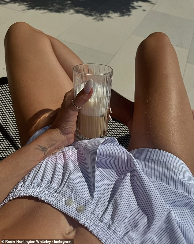 She also showed off her incredible tan from her holiday as she sported a pair of blue and white striped shorts while relaxing in her villa.