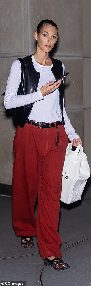 Leonardo DiCaprio's girlfriend Vittoria Ceretti, 26, showed off her cool style in a long-sleeved white blouse, a black leather vest and bright red oversized trousers.