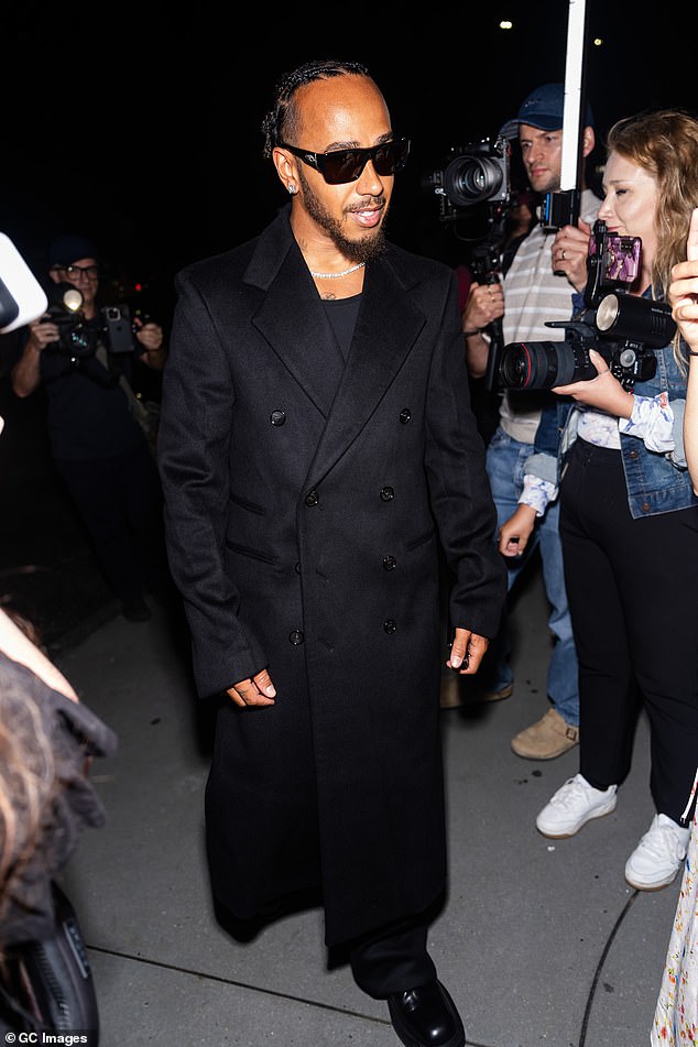 Racing driver Lewis Hamilton, 39, sported a Matrix-style look, wearing a long black coat and black sunglasses.