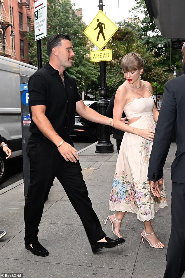 Ever the gentleman, Travis guided Taylor into the studio with a hand on her back.