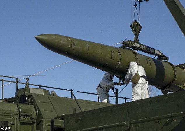 Russian troops load an Iskander missile onto a mobile launcher during military exercises at an undisclosed location in Russia