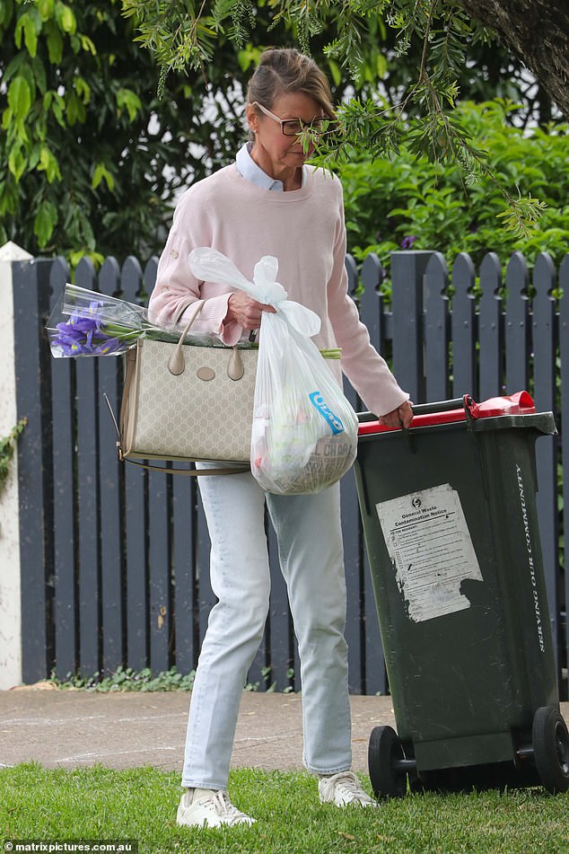 The journalist framed her face with a pair of glasses and looked somber as she left her late mother's home.