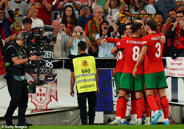 Ronaldo was mobbed by his Portugal teammates as the Lisbon stadium erupted