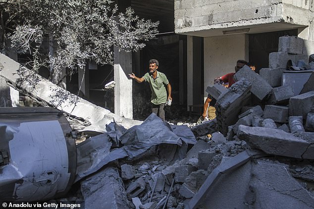 Violence in the West Bank has escalated alongside the war in Gaza, which began after Hamas attacked Israel on October 7 (pictured: people are seen in the area after the Israeli army attacked the Amr Ibn al-Aas school in Gaza City)