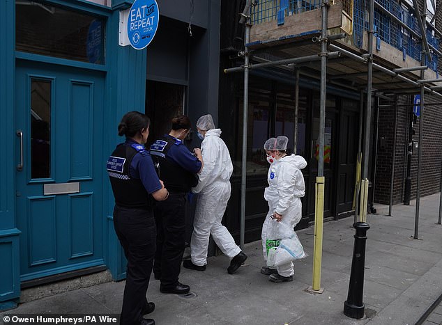 Police forensic investigators enter the disused building after contractors working on renovating a property found the skeleton of a baby beneath the floorboards on July 31.