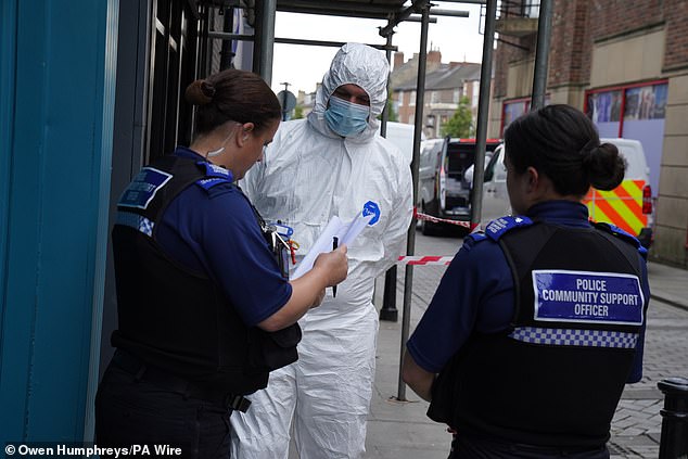 Police forensic investigators enter the disused building in Bishop Auckland on July 31