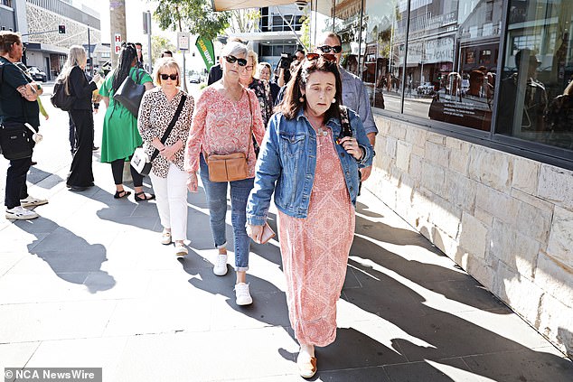 A visibly shaken woman is seen among friends and family of the crash victims outside the courthouse.