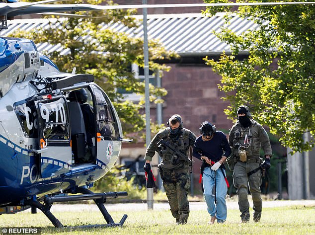 A 26-year-old Syrian man, suspected of the Solingen attack, is escorted away by police on August 25.