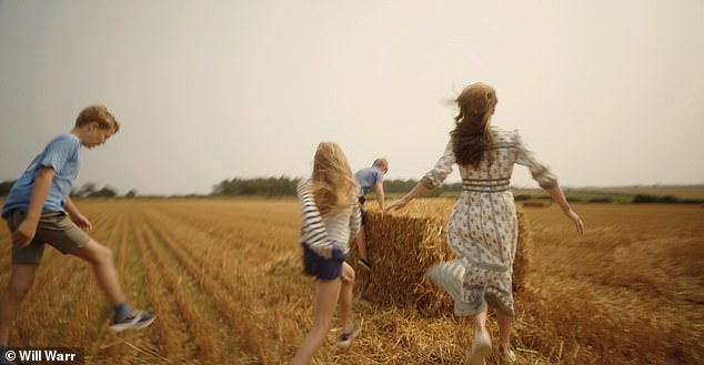 The family is also seen running through a field of freshly cut hay.