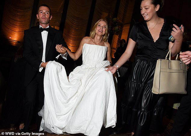 The star needed help from her carers to lift her dress as she climbed the stairs.