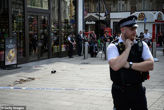 A police officer stands near a cordoned off area following a double stabbing in Leicester Square on August 12, 2024