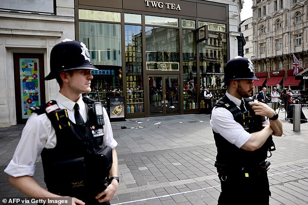 Police officers stand outside a cordoned-off area in Leicester Square, London, yesterday.